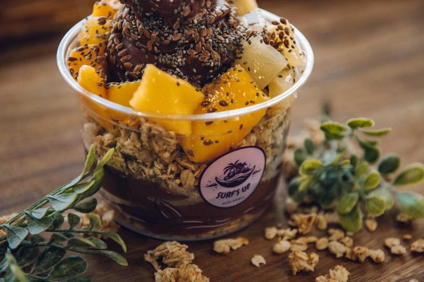 Close-up of juicy mango and pineapple over açaí and granola